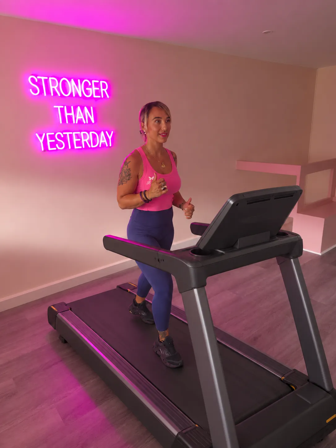 Une femme marche sur un tapis de course chez B-WIP Fitness